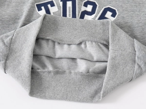 Detail of grey kid sweater showing soft French Terry lining and ribbed hemline
