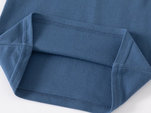 Gros plan sur l'ourlet en coton piqué bleu marine avec coutures doubles sur polo pour garçon