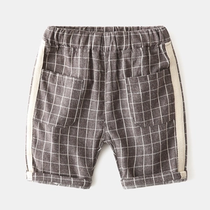 Detail view of boys' plaid cotton shorts featuring elastic waist and herringbone tape trim