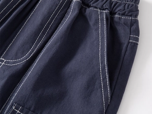 Detail of boys' navy cotton shorts featuring elastic waistband and white contrast stitching