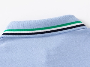 Close-up of light blue polo collar with green, white, and black striped edge detail
