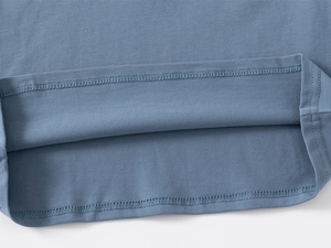 Detail of double-needle stitching and fine knit texture on toddler polo shirt hem