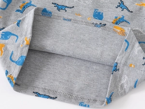 Close-up of boys' dinosaur print polo shirt hem showing neat double-needle stitching