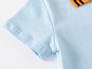 Detail of light blue cotton polo shirt sleeve with precise double-needle stitching and ribbed trim