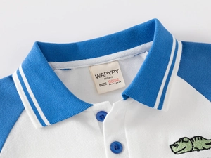 Détail du polo pour garçon avec col bleu et broderie de crocodile vert sur coton