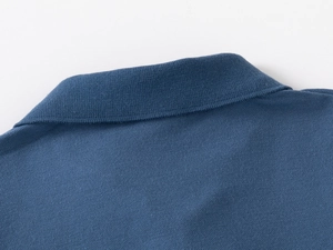Gros plan détaillé du col du polo bleu foncé et de la texture du tricot piqué respirant