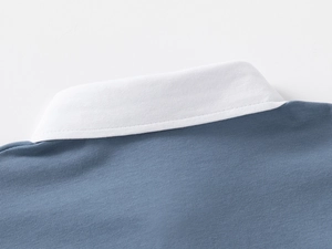 Detail of blue cotton polo shirt showing ribbed white collar and fine stitching
