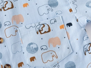 Detailed macro shot of light blue boy shirt featuring cartoon elephant prints and pocket