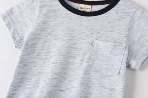 Détail d'un T-shirt gris pour enfant avec col contrasté bleu marine et poche poitrine