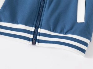 Dettaglio della giacca da baseball blu navy con cerniera in resina e bordo a righe