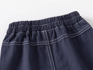Detail of navy boy's shorts featuring elastic waistband and white contrast stitching