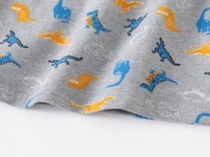Macro shot of soft grey cotton polo shirt fabric featuring colorful dinosaur print patterns