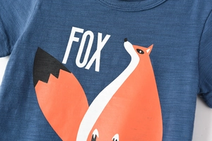 Détail de l'imprimé renard et du tissu en coton flammé sur un t-shirt bleu enfant