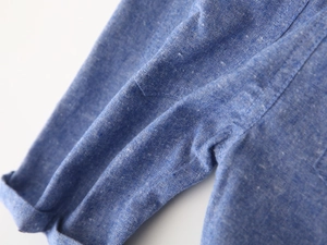 Close-up of denim blue fabric texture and double-stitch seam on boys casual shorts