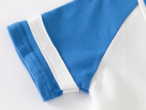 Détail de la manche bicolore bleu et blanc avec poignets rayés et texture en maille