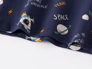Detail of space-themed prints on navy blue polo knit fabric with neat double stitching