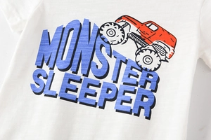 Détail d'un t-shirt en coton blanc avec imprimé graphique de monster truck rouge