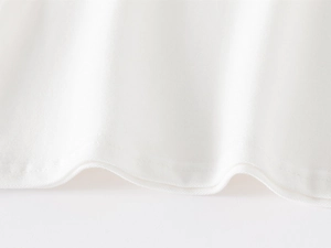 Détail de l'ourlet roulé et texture du coton fin sur ce T-shirt blanc pour garçon