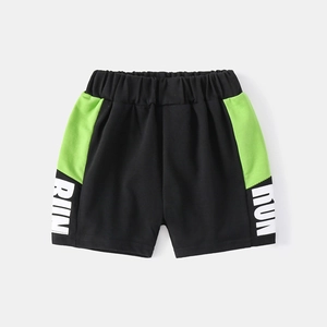 Détail de la taille élastique et de l'imprimé RUN sur short de sport enfant noir et vert