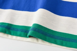 Gros plan sur les coutures overlock d'un t-shirt rayé tricolore pour enfants en coton