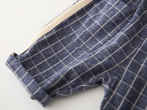 Detail of blue and white checkered boy shorts with woven tape and folded hem
