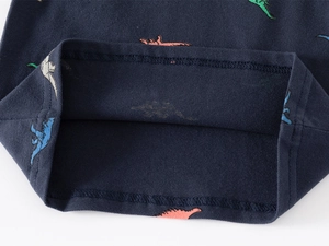 Détail du polo en coton bleu marine avec imprimé dinosaure et coutures à double aiguille