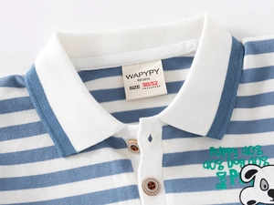 Detail of blue striped cotton polo shirt featuring wood buttons and cartoon dog print