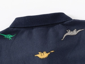 Détail du col polo bleu marine et tissu respirant avec imprimé dinosaure pour enfant