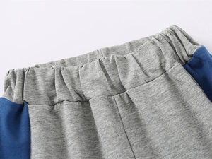 Détail des coutures à la taille et bande latérale bleue sur short en coton gris garçon