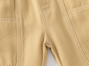 Detailed close-up of khaki cargo pants with reinforced double stitching and large patch pocket