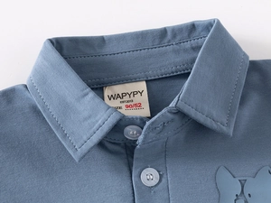 Close-up of blue polo shirt collar with buttons and embroidered puppy silhouette