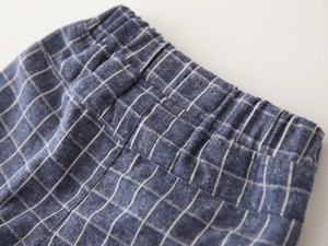 Detail of boys plaid shorts featuring elastic waistband with reinforced stitching