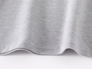 Detail of grey polo shirt fabric showing soft texture and double-needle hem stitching