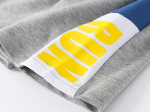 Détail du tissu en maille grise avec contraste bleu et imprimé texte RUN jaune