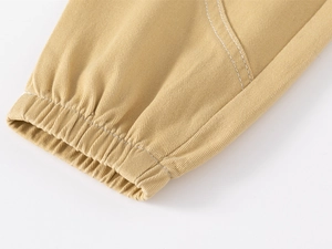 Detail of khaki jogger pants showing elastic cuff and white contrast stitching
