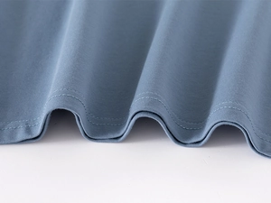 Close-up of double-stitched hem on blue cotton polo shirt showing fine textile detail