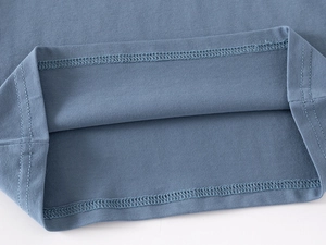 Detail of double-needle stitching and soft knit fabric texture on boys' long sleeve polo shirt