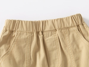 Close-up of boys khaki shorts featuring an elastic waistband and fine stitching detail