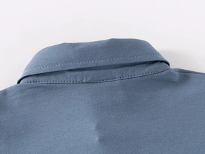 Detail of gray-blue polo collar showing precise stitching on soft cotton fabric