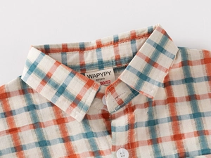 Detail of orange and cyan plaid cotton shirt with white resin buttons and collar tag