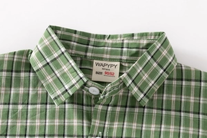 Close-up of green checkered cotton shirt collar with size tag and white buttons