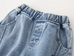 Detail of high-elasticity ribbed waistband on boys' light blue denim trousers