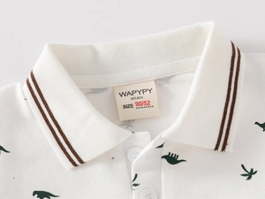 Close-up of breathable piqué cotton polo shirt with green dinosaur print and striped collar