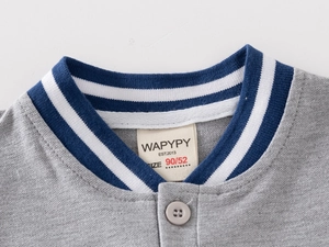Detail of grey polo shirt collar with navy striped ribbing and a single grey button