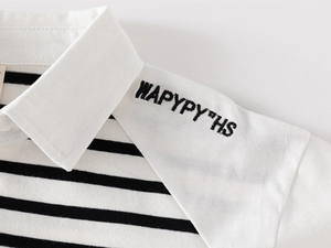 Detail of kids striped polo shirt with white collar and black letter embroidery