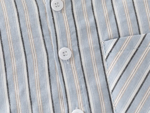 Gros plan de la chemise rayée pour garçons avec poche poitrine et texture en coton léger