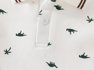 Close-up of boys white polo shirt with dinosaur prints and brown striped collar detail