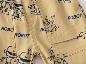 Détail du short en coton jaune avec motifs de robots bleus et texture de tissu en sergé