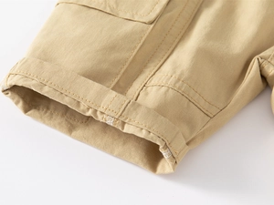 Detailed close-up of khaki cotton cargo shorts featuring double stitching and cuffed hem