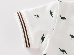 Detail of piqué cotton polo sleeve with rib cuffs and green dinosaur silhouettes